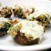 Stuffed mushrooms with melted cheese and herbs on a white plate, crafted with love by Owl Creek Farm.