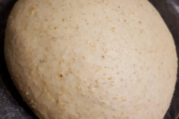 A ball of dough from Owl Creek Farm rests quietly on a dark countertop.