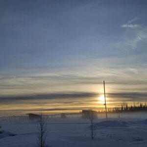 a photo of a sun setting over a snow covered farm on the Winter Solstice by owlcreek.ca